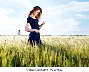 Woman At Wheat Field On Sunny Day