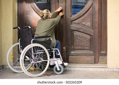 Woman In Wheelchair In Front Of Entrance Door Trying To Get In