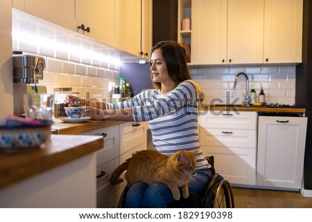 Woman in wheelchair in kitchen at home
