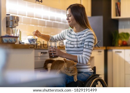 Woman in wheelchair in kitchen at home
