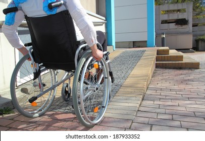 Woman in a wheelchair using a ramp - Shutterstock ID 187933352