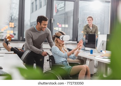 woman in wheelchair using virtual reality glasses at modern office - Powered by Shutterstock