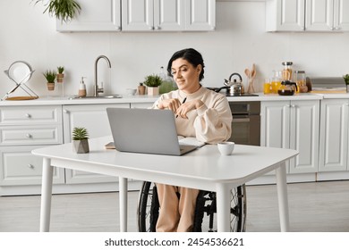 A woman in a wheelchair works remotely at a kitchen table, using a laptop computer to stay connected and productive. - Powered by Shutterstock