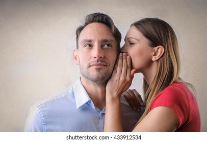 Woman whispering into a man's ear