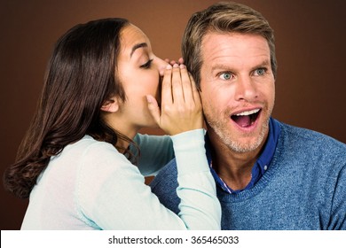 Woman whispering secret with man against shades of brown - Powered by Shutterstock