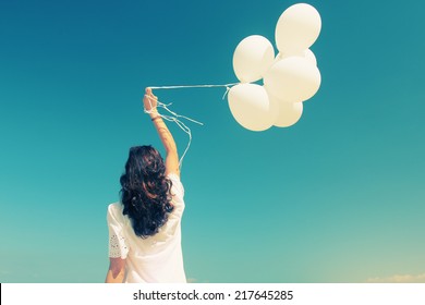 Woman With White Balloons On Seaside