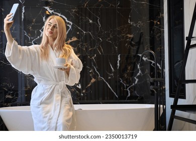 Woman in white bathrobe making selfie on smartphone in bathroom - Powered by Shutterstock