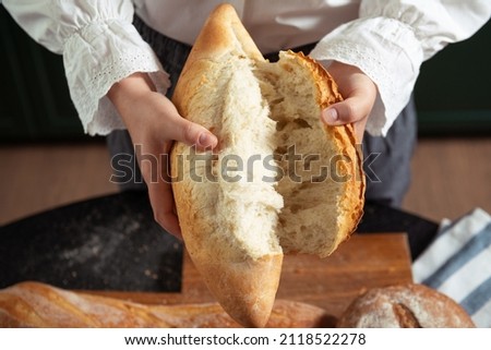 Woman in white blouse hands tear white wheat bread domestic cozy bakery pastry warm tasty textured