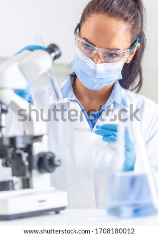 Similar – Image, Stock Photo Female chemist hand holding magnifying glass to analyze golden glitter sample on petri dish in lab