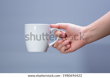 Similar – Foto Bild Frau Hand, die eine Tasse Kaffee von einem Holztisch im Garten aufzieht.