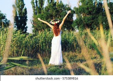 Woman In White Dress Standing In Field Wearing Flower Crown. Young Forest Inspired Bride, Bohemian Girl