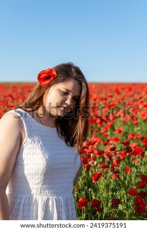 Woman in a white dress walks on a croppy poppy field Stock photo © 