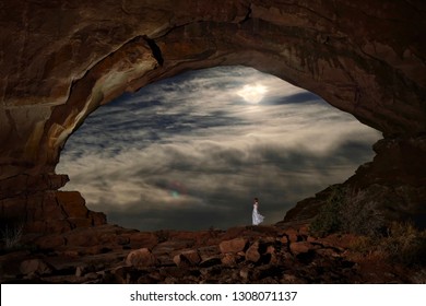 Woman in white dress in Window Arch with full moon through clouds. Arches National Park near Moab. Utah. USA.​ - Shutterstock ID 1308071137