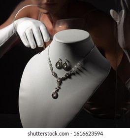 A Woman In White Gloves Stealing Jewelry