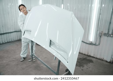 Woman in white protective gear works in a paint shop - Powered by Shutterstock