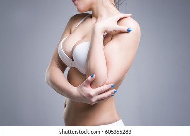 Woman in white push up bra on gray background, perfect female breast, studio shot