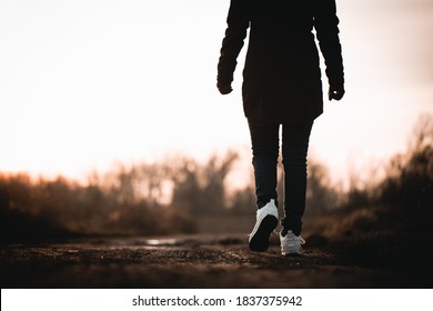 Woman In White Shoes Walking On The Muddy Ground