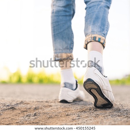 woman in white sneakers steps on ground