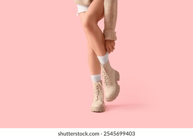 Woman in white socks with boots on pink background