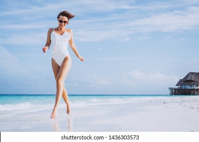 Woman In White Swimming Suit By The Ocean