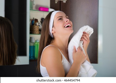 Woman With A White Towel Drying Up Her Face After Washing