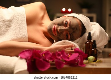 Woman In White Towel Lie On Couch With Mask On Her Face In Spa Salon And Do Aromatherapy Procedures With Oils.