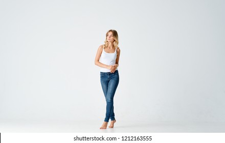 Woman In White T-shirt And Jeans Barefoot                       