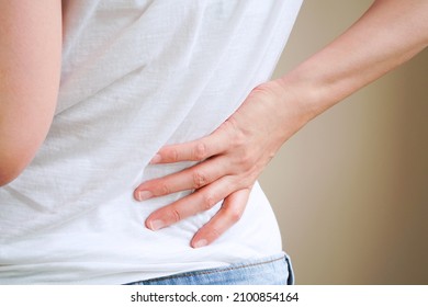 Woman In White T-shirt Touch Her Waist And Hold Lower Back Which Suffering From Back Pain Or Back Ache