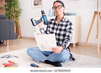 Woman who is assembling furniture in her home as part of a renovation project. She is using a variety of tools - Powered by Shutterstock