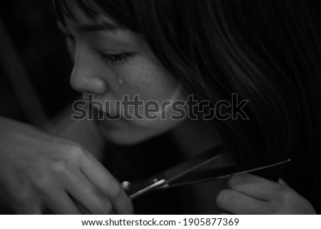 A woman who cuts her hair while crying