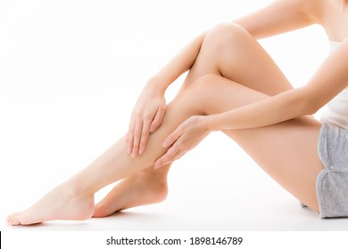 A woman who does skin care for her legs. - Shutterstock ID 1898146789