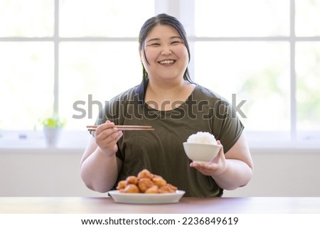 A woman who eats a large bowl of rice
