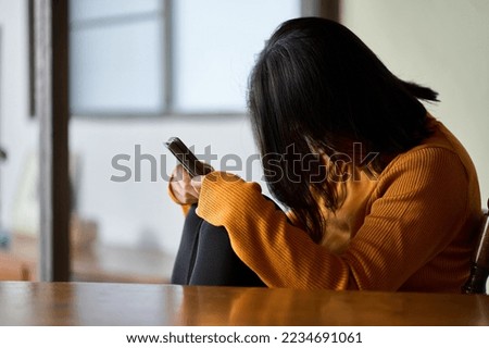 A woman who feels depressed looking at her smartphone