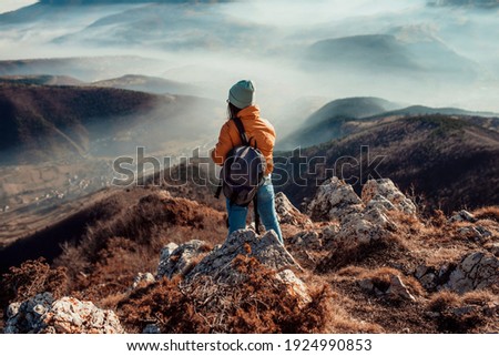 a woman who hikers enjoys a break look at the top of the mountain