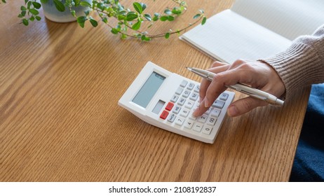 A woman who keeps a household account book. - Shutterstock ID 2108192837