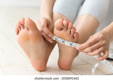 A woman who measures the size of the instep.