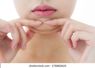 A woman who pinches the fat on her jaw.