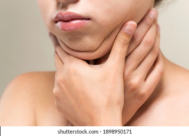 A woman who pinches the fat on her jaw.