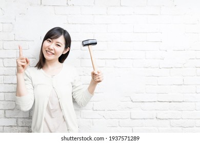 Woman Wielding A Hammer Near Wall