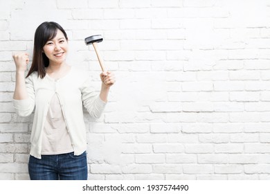 Woman Wielding A Hammer Near Wall