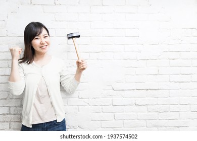 Woman Wielding A Hammer Near Wall