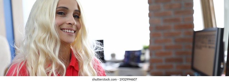 Une femme en perruque aux cheveux blancs est assise à table et sourit. Modification de l'apparence avec le concept de perruques