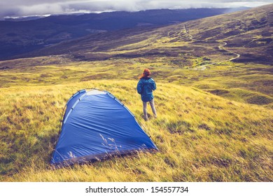 Woman Wild Camping On Grassy Mountain Top