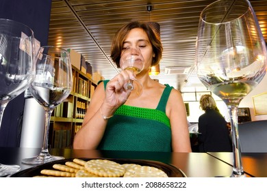  Woman In Wine Tasting Sampling With Glasses And People Unfocused In Background