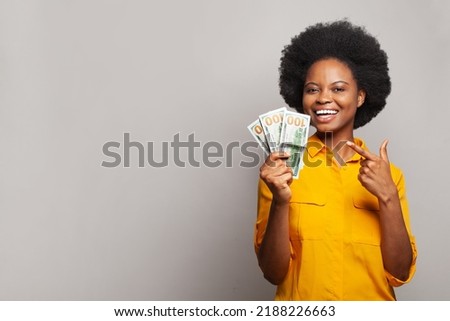 Woman winning money. Happy woman with surprised expression holding bunch of hundred dollar bill banknotes in her hand. Finances and people concept