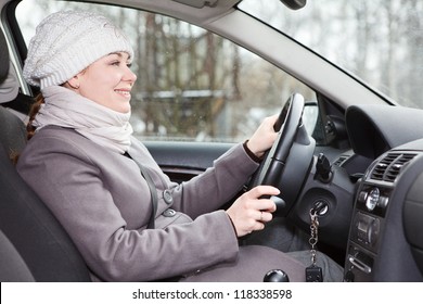 Woman In Winter Clothes Driving A Car Looking Forward