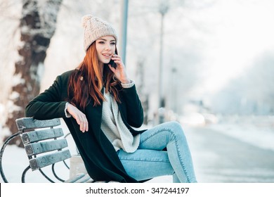 Woman In Winter Park Talking Mobile Phone, Sms, Sitting On The Bench