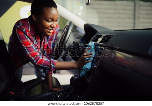 Woman wipes\
car interior with rag, hand auto\
wash