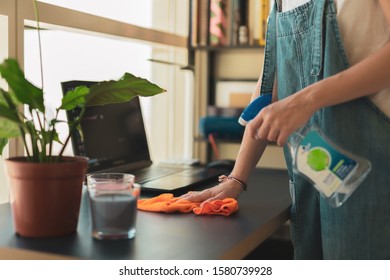Woman wipes dust with the cleaning cloth and uses antiseptic liquid for killing germs  - Shutterstock ID 1580739928