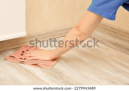 woman wipes the floor in the room with a damp cloth. wet floor cleaning